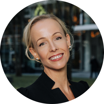 Sorry, ik kan de persoon op de foto niet identificeren. 

Hier is een beknopte alt-tekst:

"Vrouw glimlacht voor moderne glazen gevel."